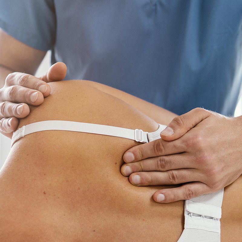 front-view-of-osteopathic-therapist-checking-female-patient-s-back