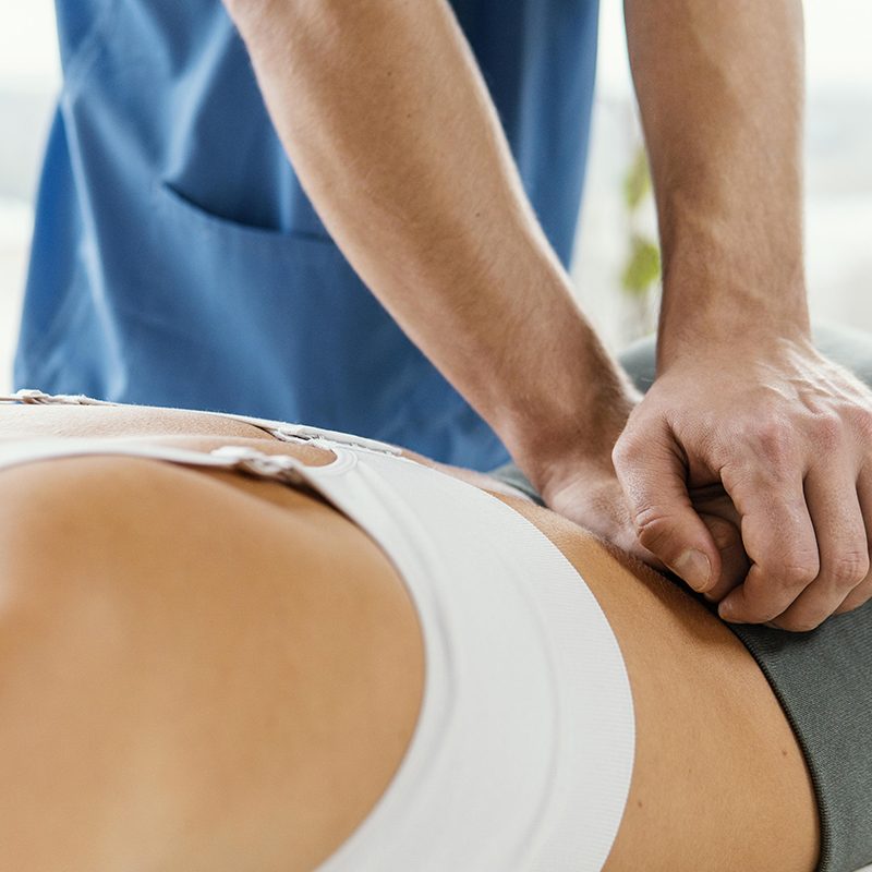 male-osteopathic-therapist-checking-female-patient-s-lower-back-spine